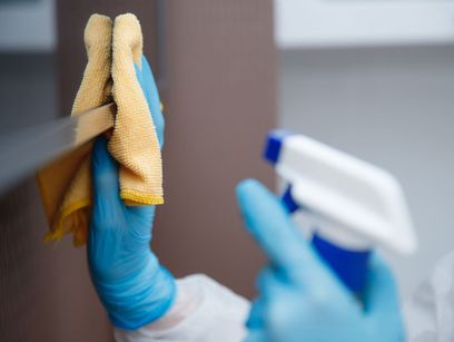 persona limpiando superficie con guantes