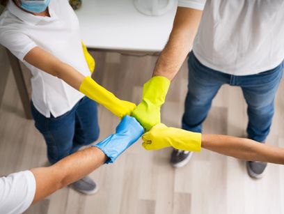 personas con guantes de limpieza juntando manos